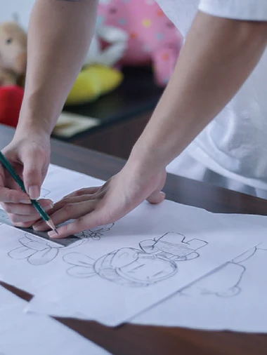 Hand sketching initial artwork design for custom keychain production